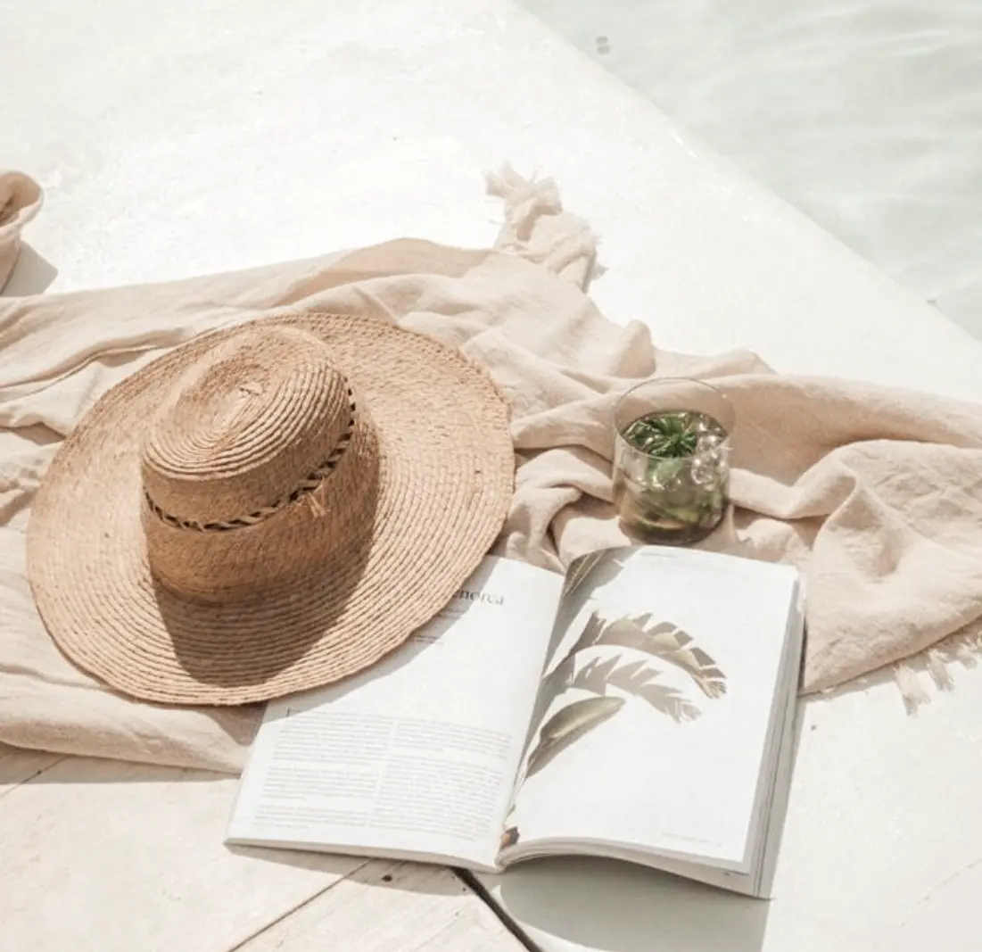 Hand wearing Cala Luna rings while holding a book in a cosy reading spot